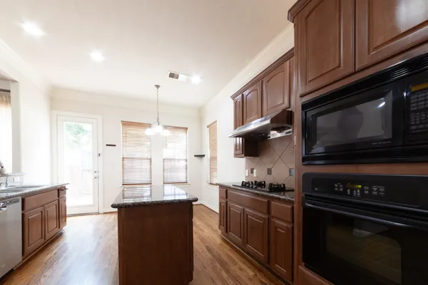 a kitchen with stainless steel appliances kitchen island granite countertop a stove refrigerator and microwave