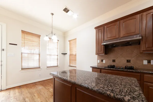 a kitchen with granite countertop wooden cabinets and a window
