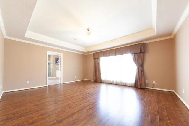 a view of an empty room with wooden floor