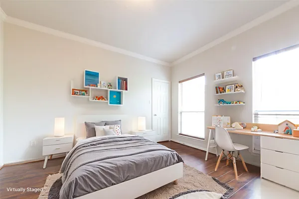 a bedroom with a bed and a desk in it with window