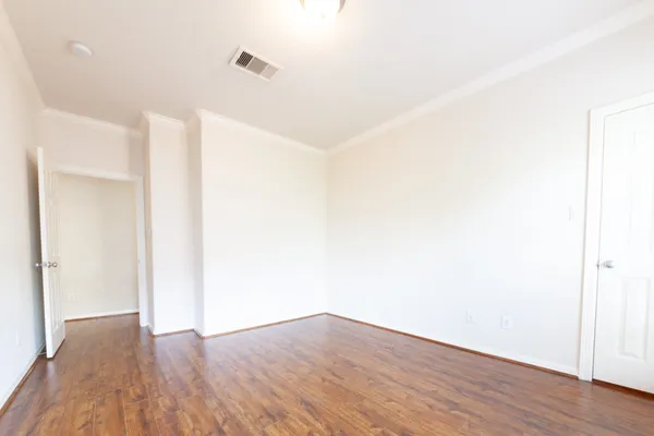 a view of an empty room with wooden floor