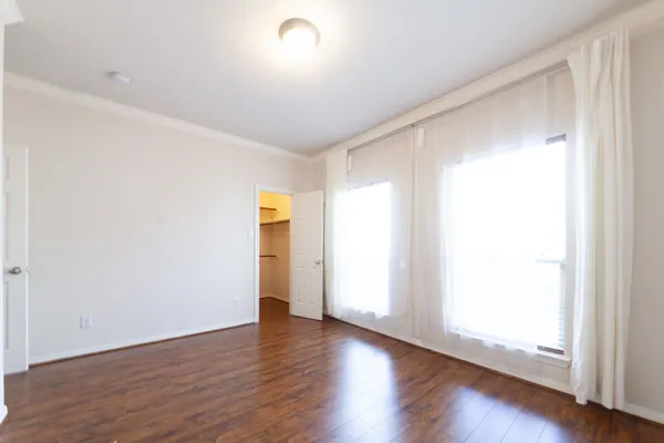 an empty room with wooden floor and natural light