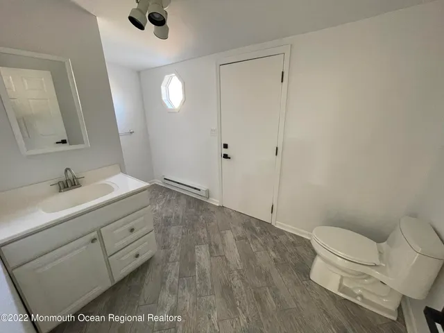 a bathroom with a sink a toilet and a mirror