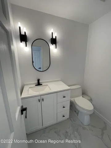 a bathroom with a toilet a sink and mirror