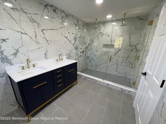 a bathroom with a sink mirror and shower
