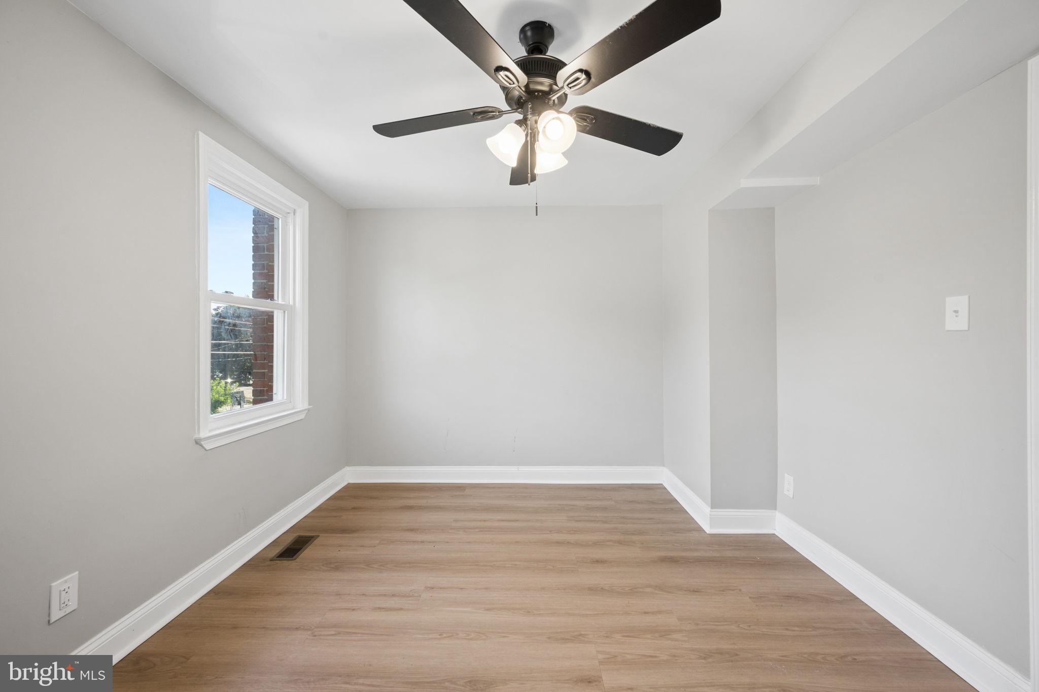 3548 Benzinger Road Baltimore, MD 21229 - Photo 17 of 40 an empty room with wooden floor chandelier fan and windows
