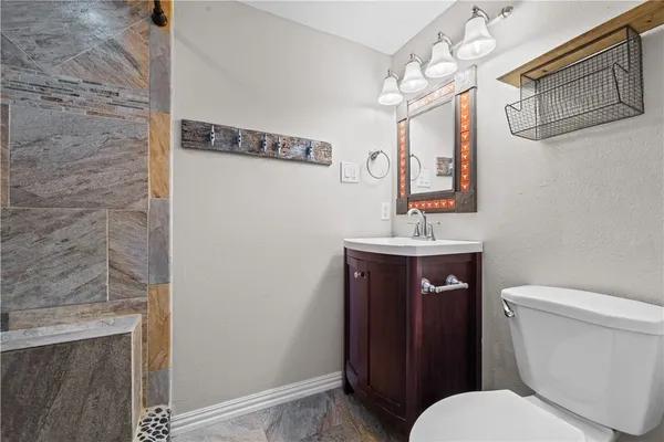 a bathroom with a toilet a sink and mirror