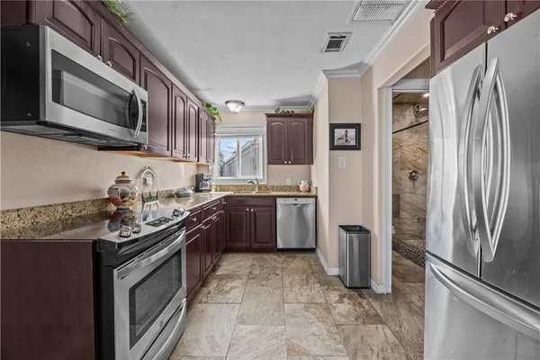a kitchen with stainless steel appliances granite countertop a refrigerator stove and sink