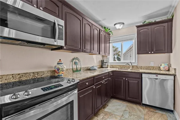 a kitchen with stainless steel appliances granite countertop a sink stove and microwave