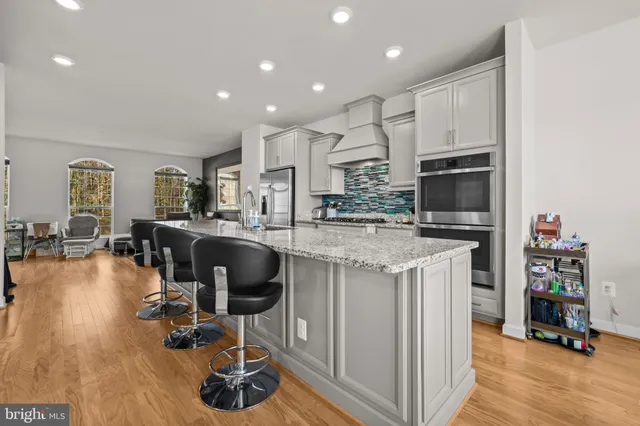a kitchen with kitchen island granite countertop a stove and a wooden floors