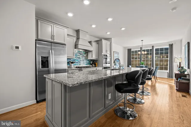 a kitchen with granite countertop kitchen island stainless steel appliances a sink and counter space