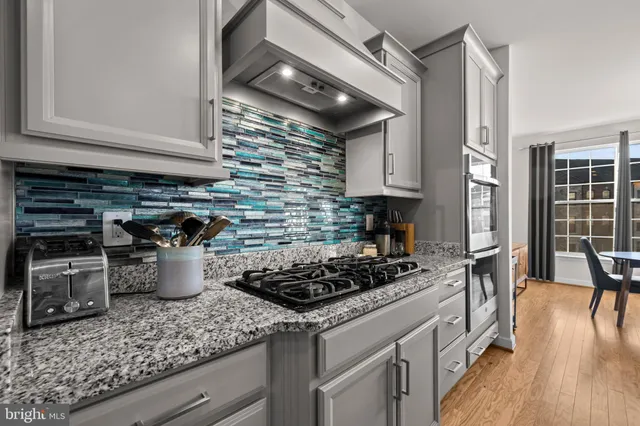a kitchen with a stove and a wooden floor