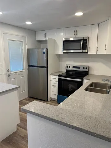 a kitchen with a refrigerator a microwave and sink