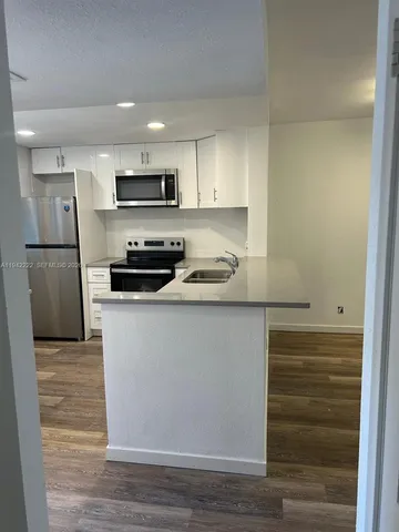 a kitchen with a sink stainless steel appliances and counter space