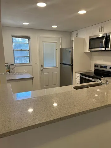 a kitchen with stainless steel appliances a refrigerator sink and microwave