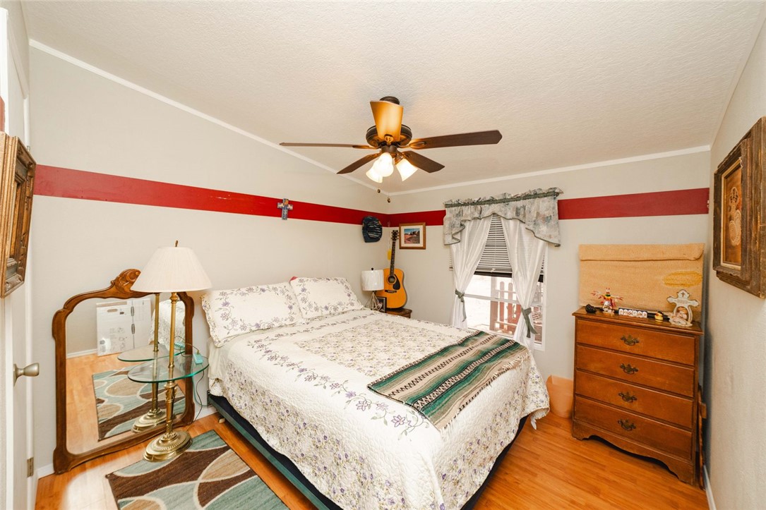 18488 Golf Course Avenue Wikieup, AZ 85360 - Photo 16 of 41 MAIN HOUSE Bedroom 2 featuring light wood-style flooring, a ceiling fan, a textured ceiling, and ornamental molding