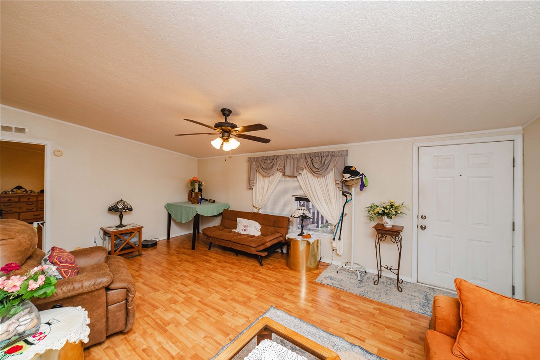 18488 Golf Course Avenue Wikieup, AZ 85360 - Photo 6 of 41 MAIN HOUSE: Living area with light wood-type flooring, ceiling fan, a textured ceiling, and ornamental molding