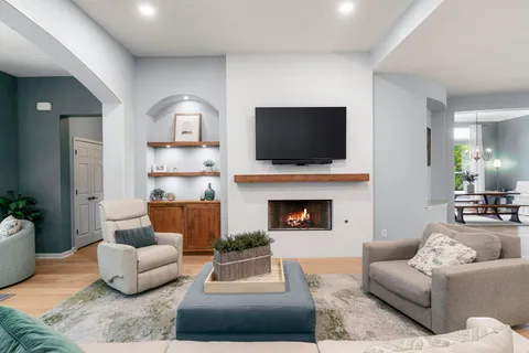 a living room with furniture a fireplace and a flat screen tv