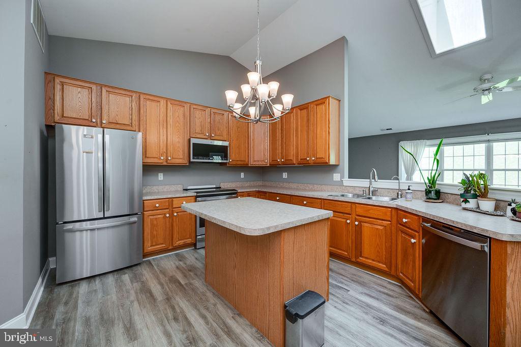 314 Charleston Lane Reading, PA 19610 - Photo 4 of 23 a kitchen with stainless steel appliances granite countertop a refrigerator a sink dishwasher a stove and white countertops with wooden floor