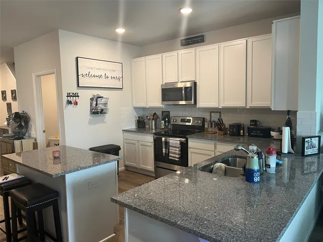 a kitchen with stainless steel appliances granite countertop a stove and a microwave