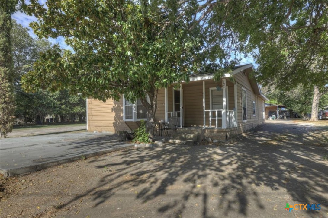 a front view of a house with a yard and potted plants