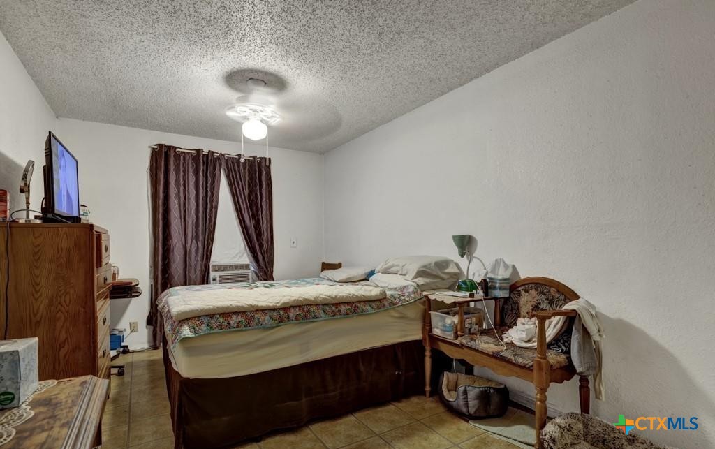 512 Valley Street San Marcos, TX 78666 - Photo 16 of 45 a bedroom with a bed and a chandelier