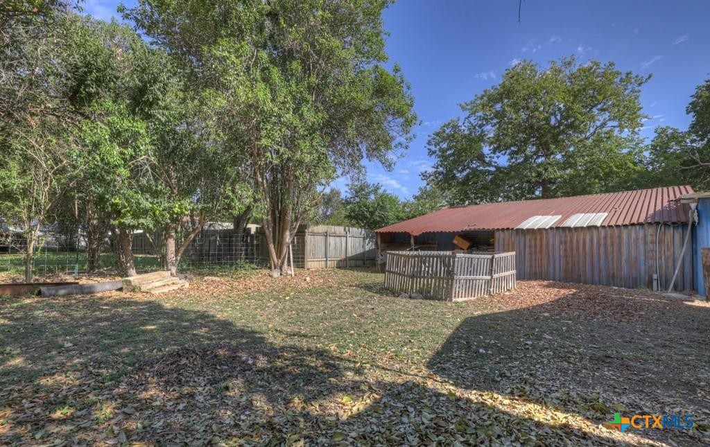 512 Valley Street San Marcos, TX 78666 - Photo 9 of 45 a backyard of a house with large trees and wooden fence