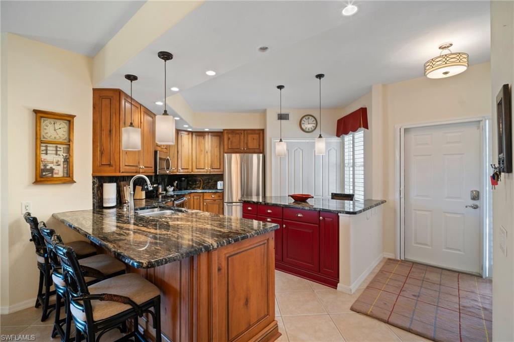 9281 Spring Run Boulevard, Unit 2607 Estero, FL 34135 - Photo 14 of 46 a kitchen with stainless steel appliances granite countertop a stove a sink dishwasher and a refrigerator with wooden floor