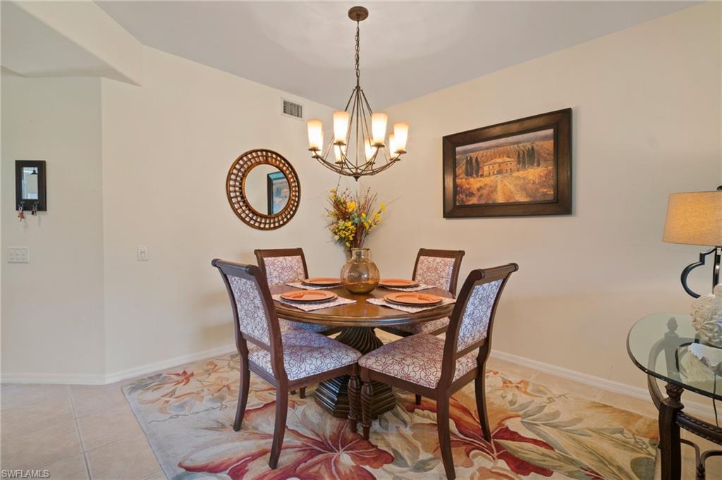 9281 Spring Run Boulevard, Unit 2607 Estero, FL 34135 - Photo 20 of 46 a dining room with furniture a chandelier and wooden floor