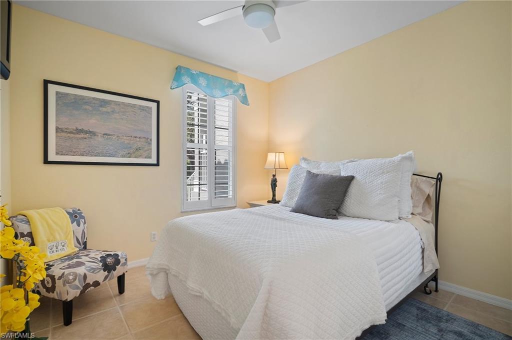 9281 Spring Run Boulevard, Unit 2607 Estero, FL 34135 - Photo 36 of 46 a bedroom with a bed and a chandelier