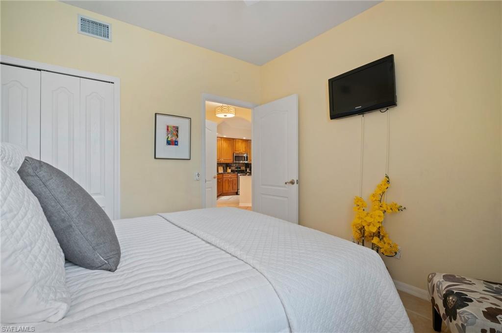 9281 Spring Run Boulevard, Unit 2607 Estero, FL 34135 - Photo 37 of 46 a bedroom with a bed and a flat screen tv