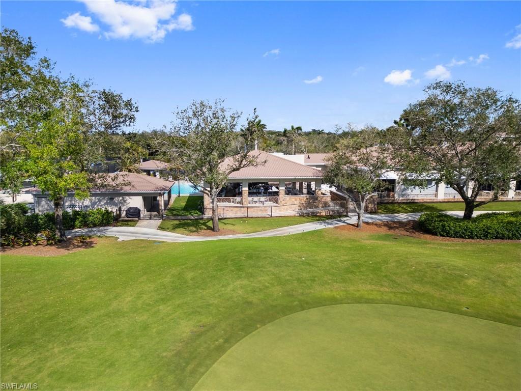 9281 Spring Run Boulevard, Unit 2607 Estero, FL 34135 - Photo 44 of 46 a view of a big house with a big yard and large trees