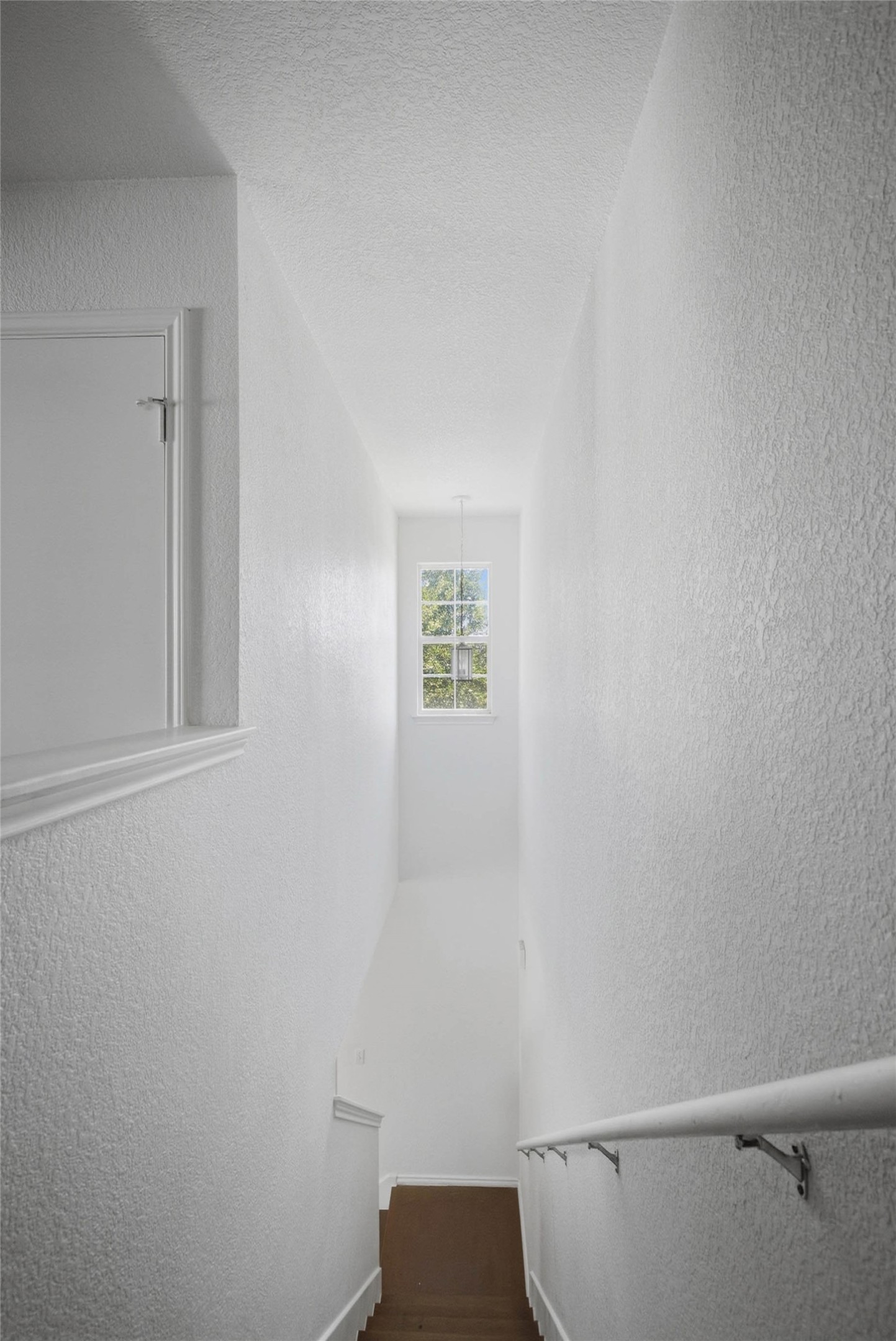 13808 Harris Ridge Boulevard, Unit B Pflugerville, TX 78660 - Photo 25 of 33 Natural light from a tall window illuminates a clean-lined stairway with warm wood flooring.