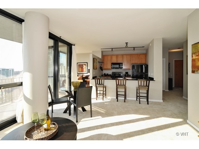 210 South Desplaines Street, Unit 910 Chicago, IL 60661 - Photo 5 of 12 a living room with stainless steel appliances kitchen island granite countertop furniture and a kitchen view