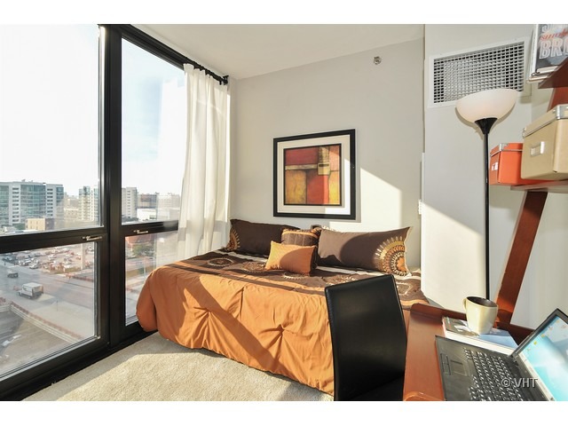 210 South Desplaines Street, Unit 910 Chicago, IL 60661 - Photo 6 of 12 a bed room with a bed window and a flat screen tv