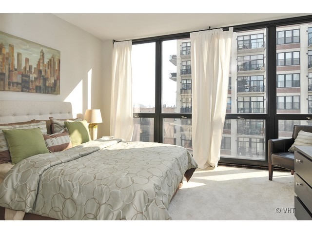 210 South Desplaines Street, Unit 910 Chicago, IL 60661 - Photo 7 of 12 a bedroom with a large bed and a large window
