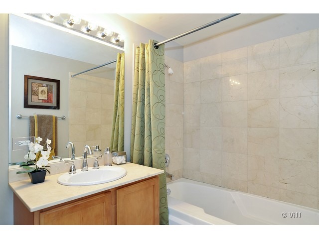 210 South Desplaines Street, Unit 910 Chicago, IL 60661 - Photo 8 of 12 a bathroom with a sink mirror and a shower