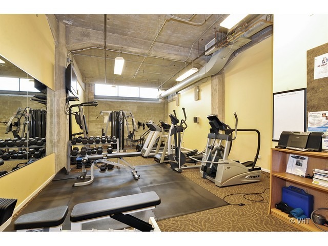 210 South Desplaines Street, Unit 910 Chicago, IL 60661 - Photo 9 of 12 a room with gym equipment and mirror
