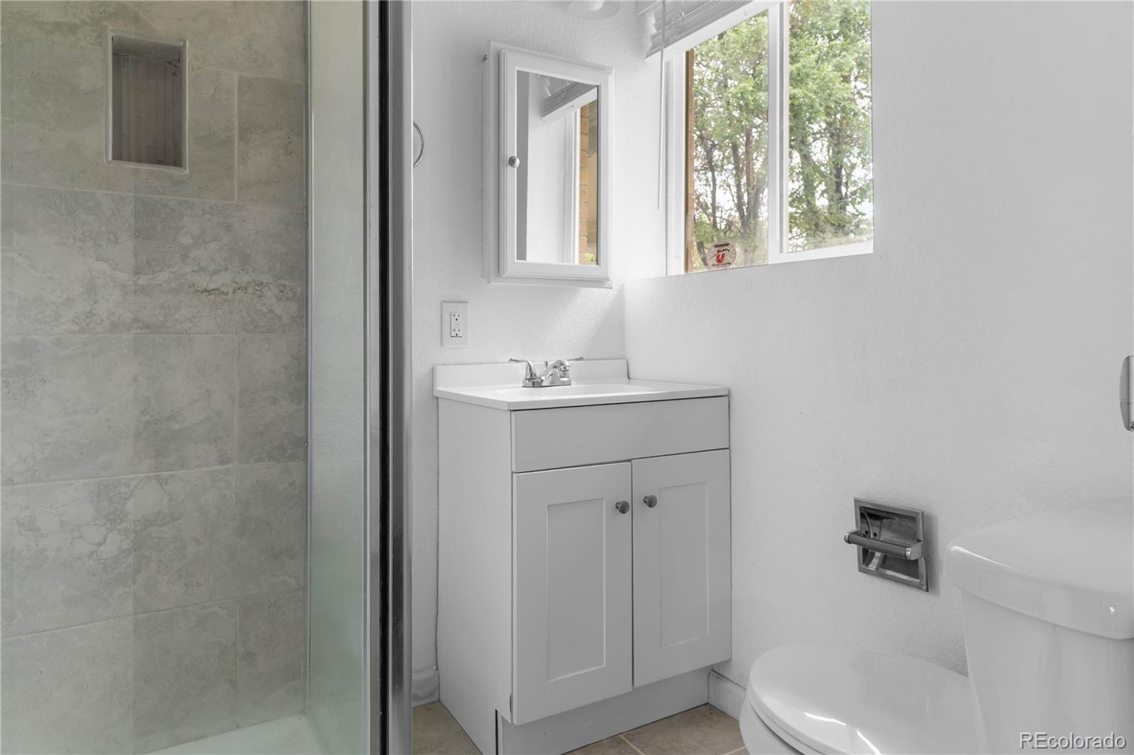 7010 West 44th Avenue Wheat Ridge, CO 80033 - Photo 19 of 31 a bathroom with a sink and a mirror