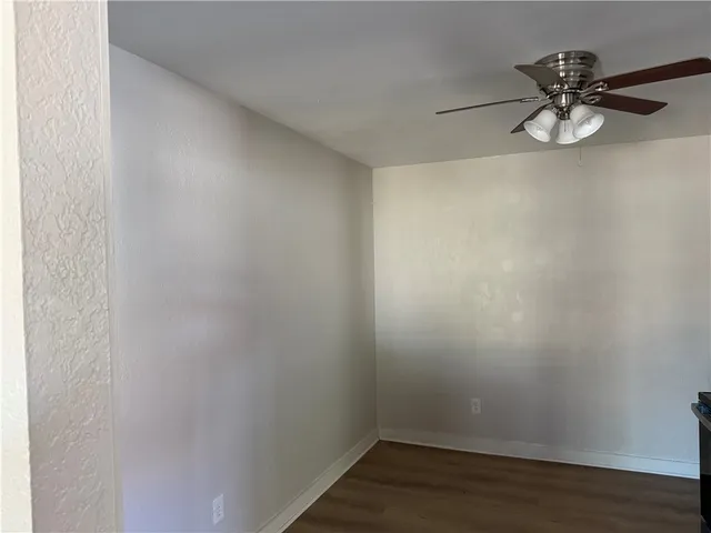 a view of a room with wooden floor and fan