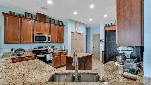 a kitchen with stainless steel appliances granite countertop a sink stove and refrigerator