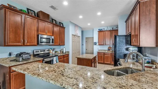 a kitchen with stainless steel appliances granite countertop a sink stove and refrigerator