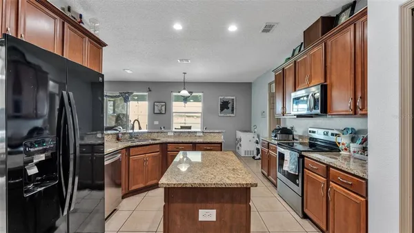 a kitchen with stainless steel appliances granite countertop a sink stove and refrigerator
