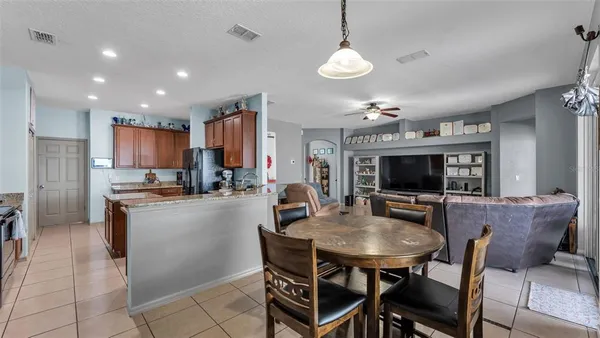 a kitchen with a dining table chairs and refrigerator