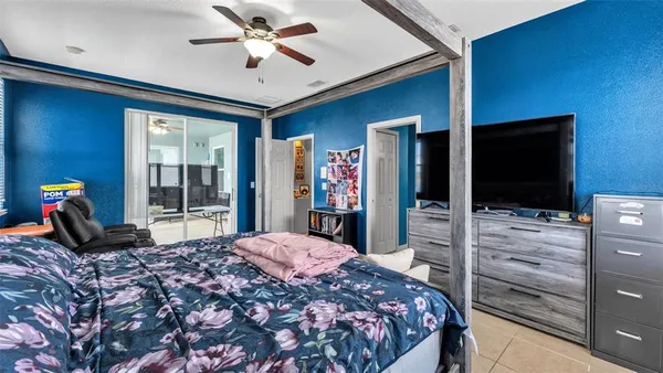 a bedroom with a bed and a flat tv screen on dresser