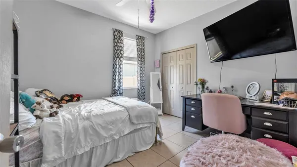 a bedroom with a bed a flat screen tv and dresser