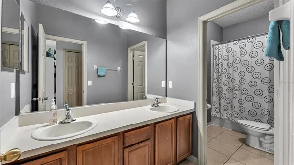 a bathroom with a double vanity sink toilet and shower