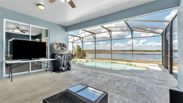 a view of a livingroom with furniture flat screen tv and floor to ceiling window