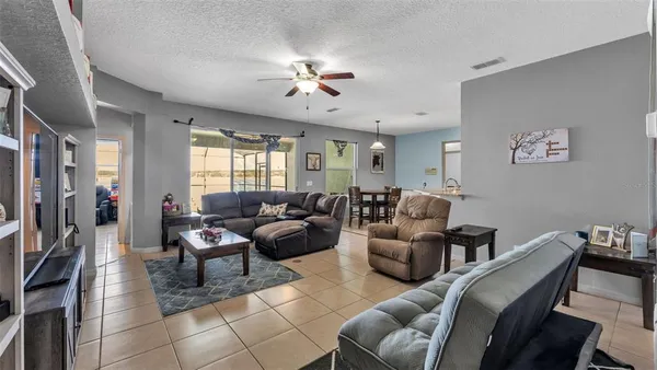 a living room with furniture a chandelier and a dining table