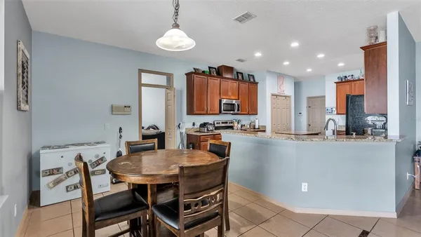 a kitchen with a dining table chairs and microwave